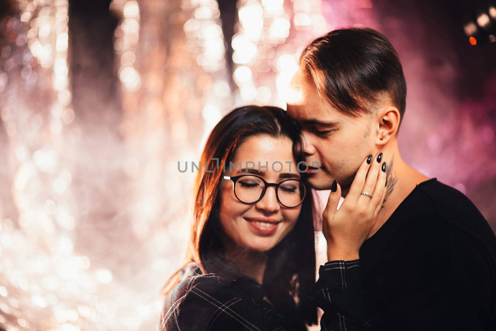 Couple in fashionable clothes on a shiny background.