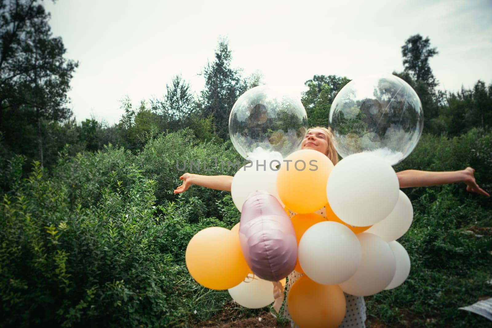 portrait of young girl with balloons on nature background.