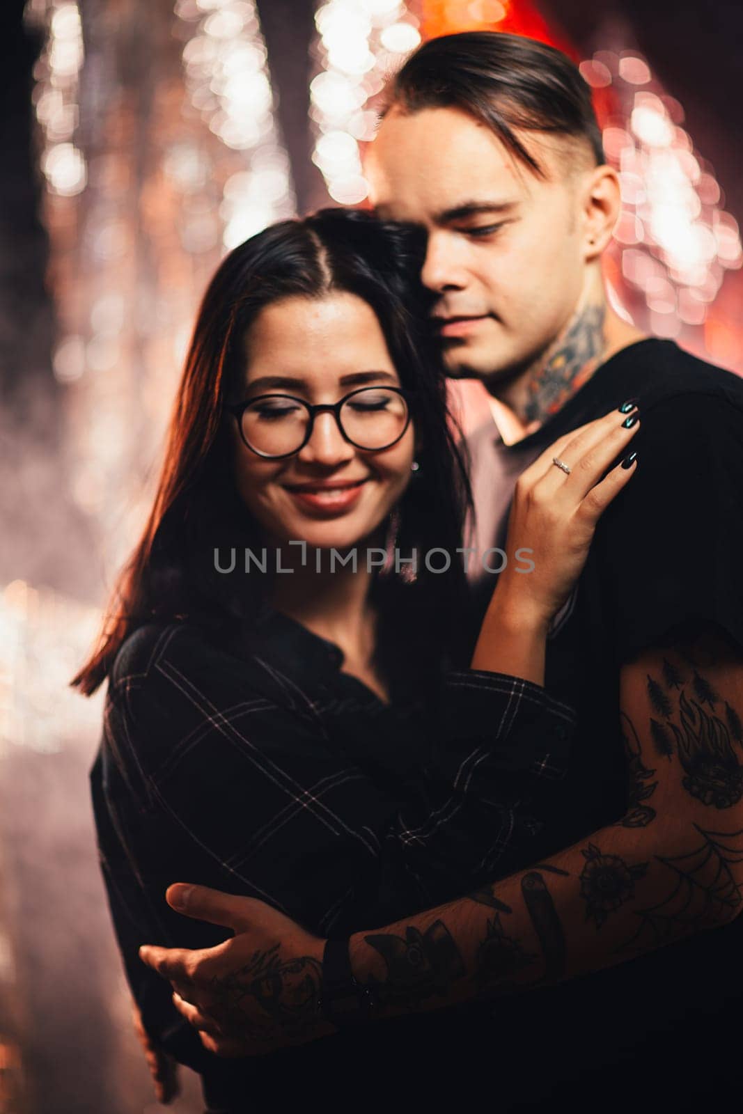 Couple in fashionable clothes on a shiny background.