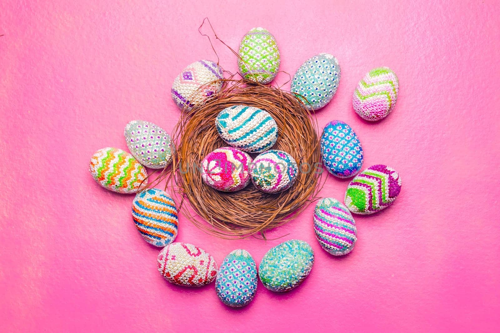 Colorful easter eggs in the nest and a pink background. Happy Easter