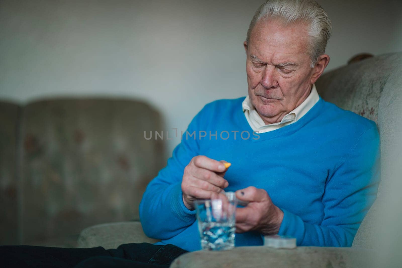 Senior man is taking his medication and vitamins at home.