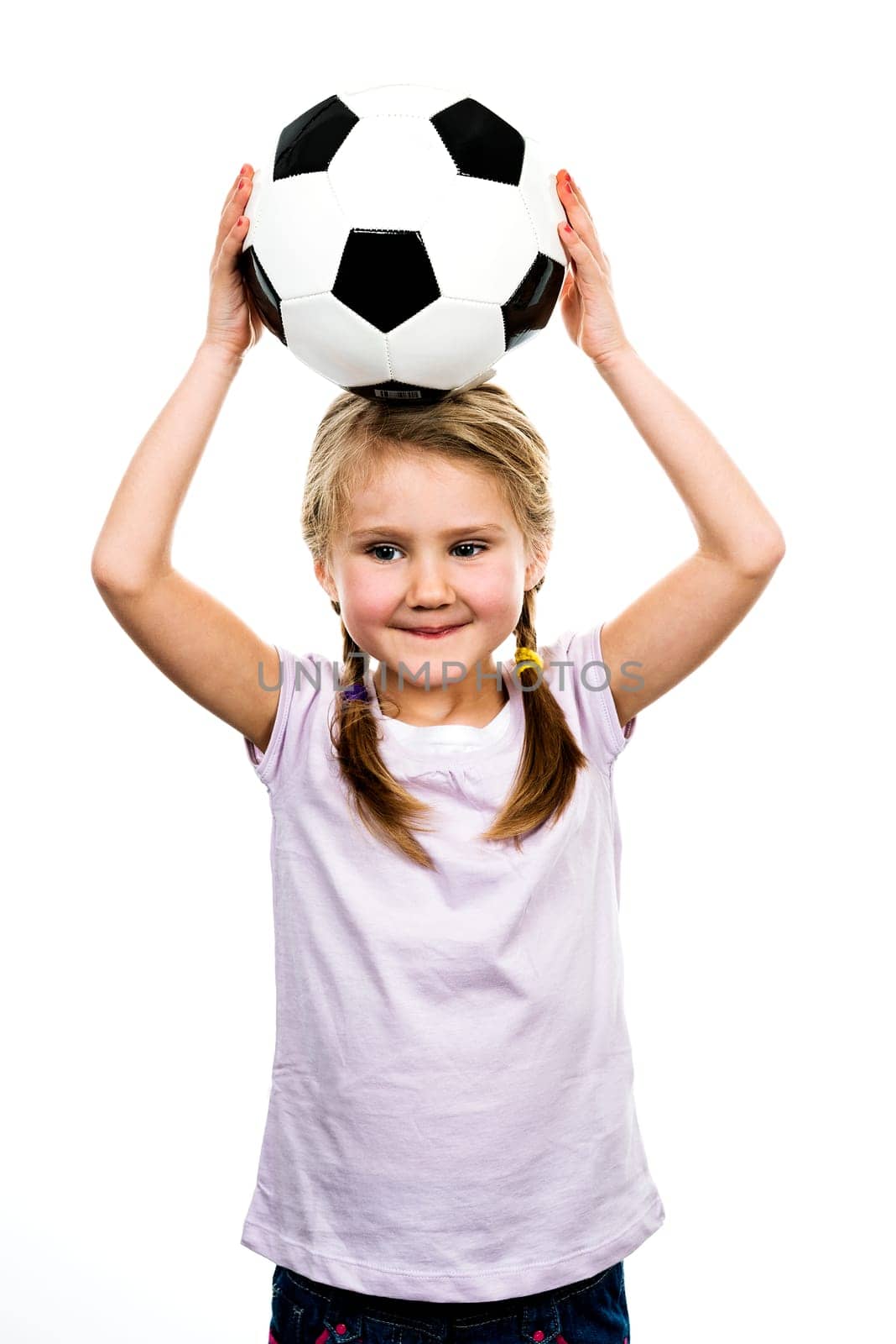 Cute girl playing football, happy child, young female goalkeeper enjoying sport game, holding ball, isolated portrait of a preteen smiling and having fun, kids activities, little footballer