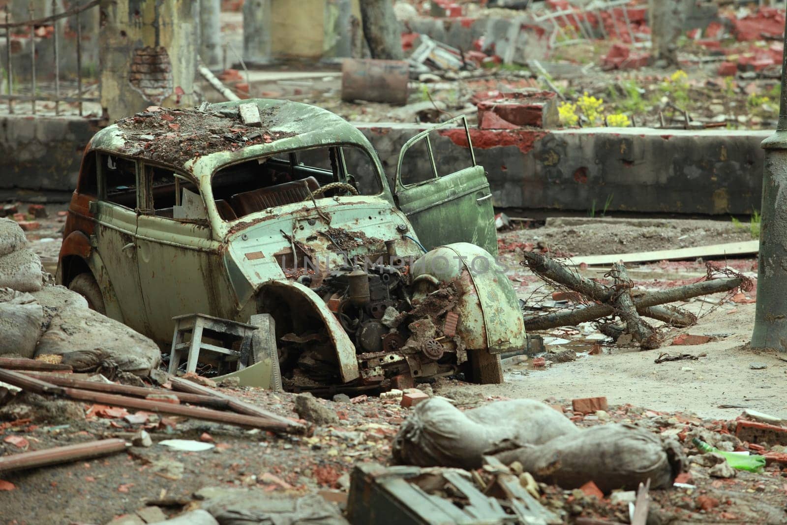 wrecked car among ruins on street in the city
