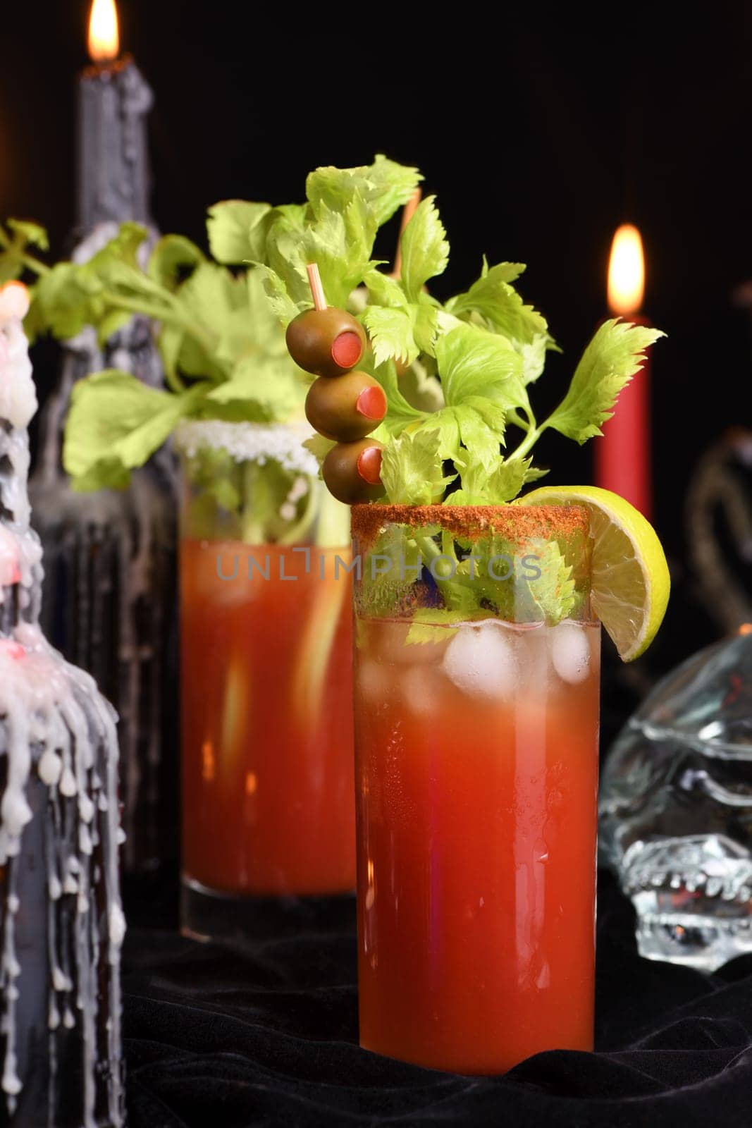 Bloody Mary cocktail. Tomato juice and vodka, garnished with celery stalk, lime and olives. Halloween party ideas.  
