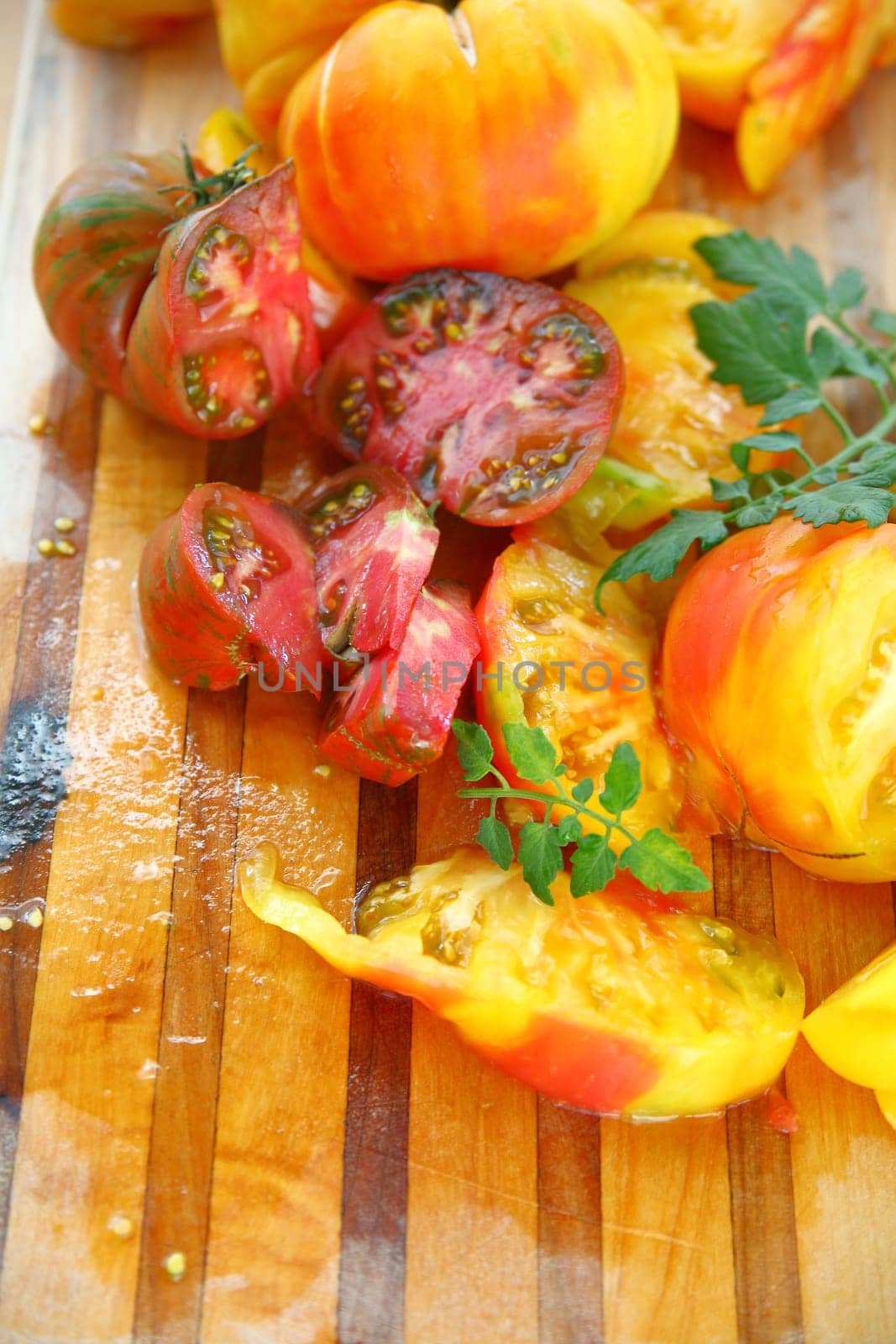Vertical view of fresh, ripe tomatoes with juices on a cutting board