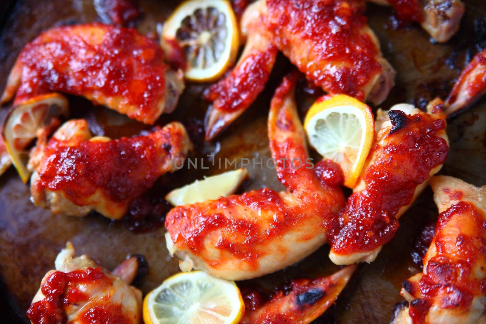 Overhead view of chicken wings with barbecue sauce and lemon