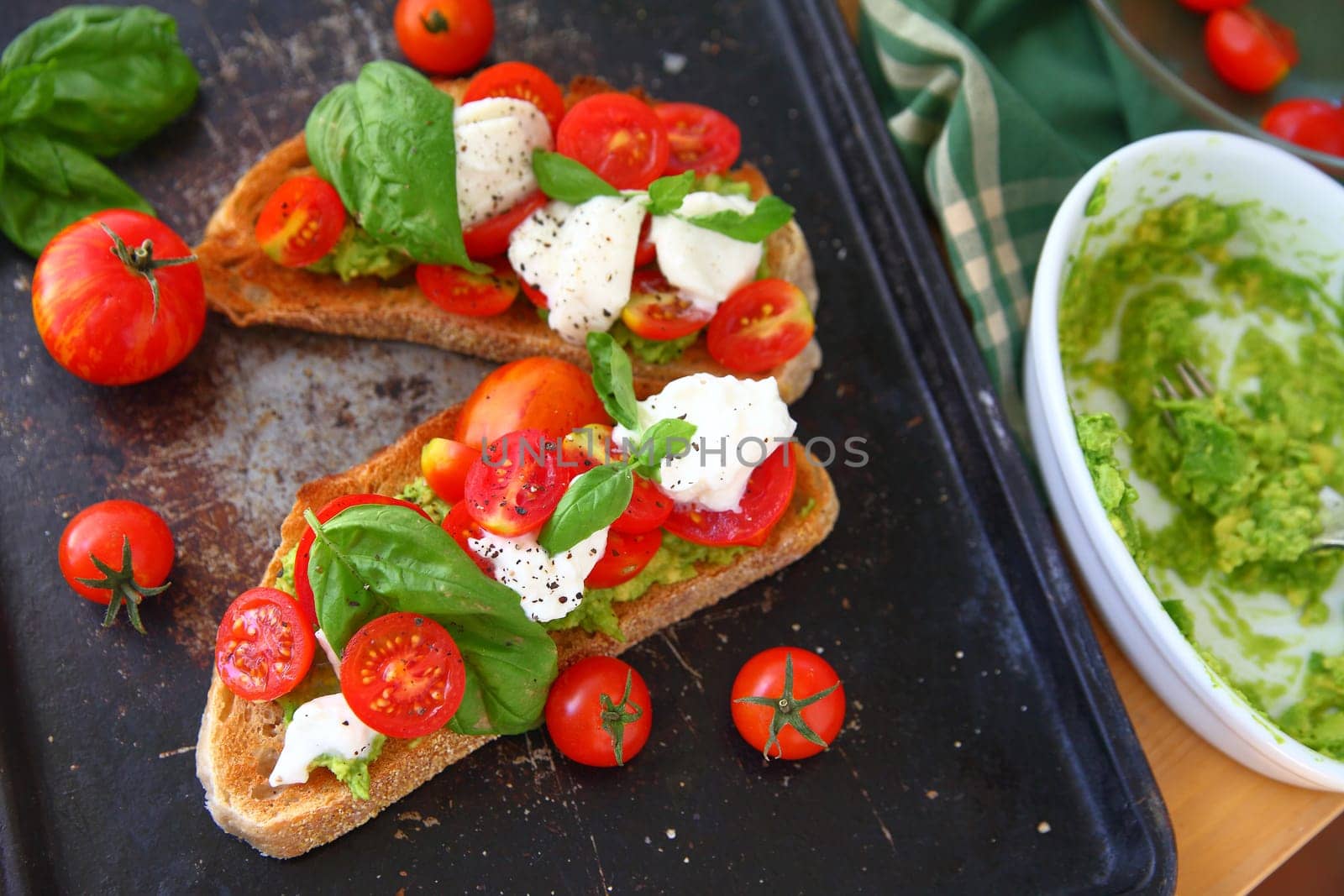 Making avocado toast with caprese salad on top