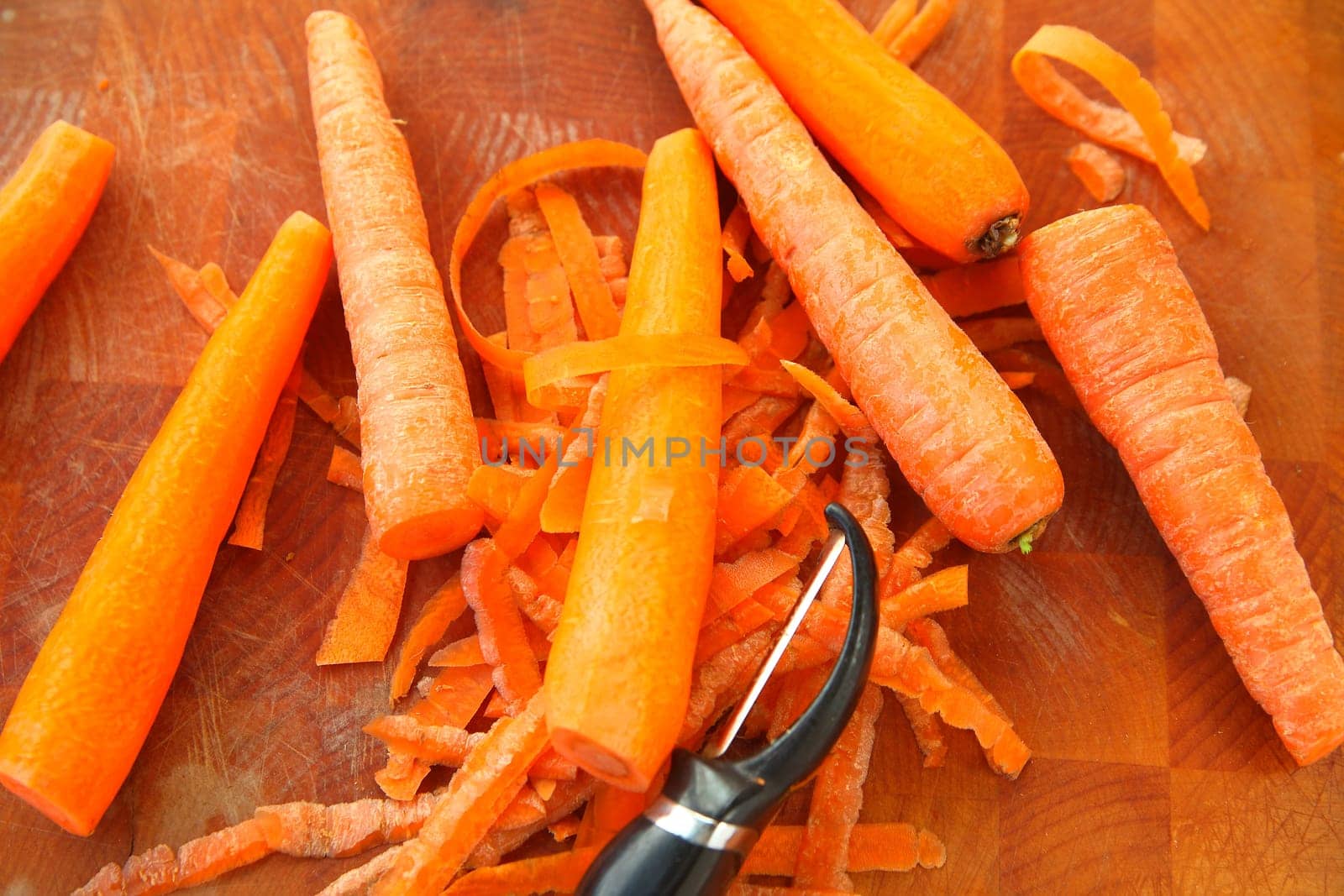 Several carrots with a peeler