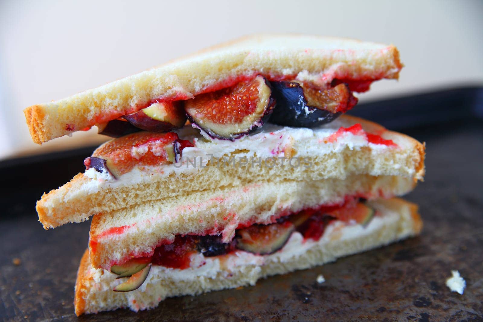 Fruit sandwich with cream cheese and jam, cut in half and stacked