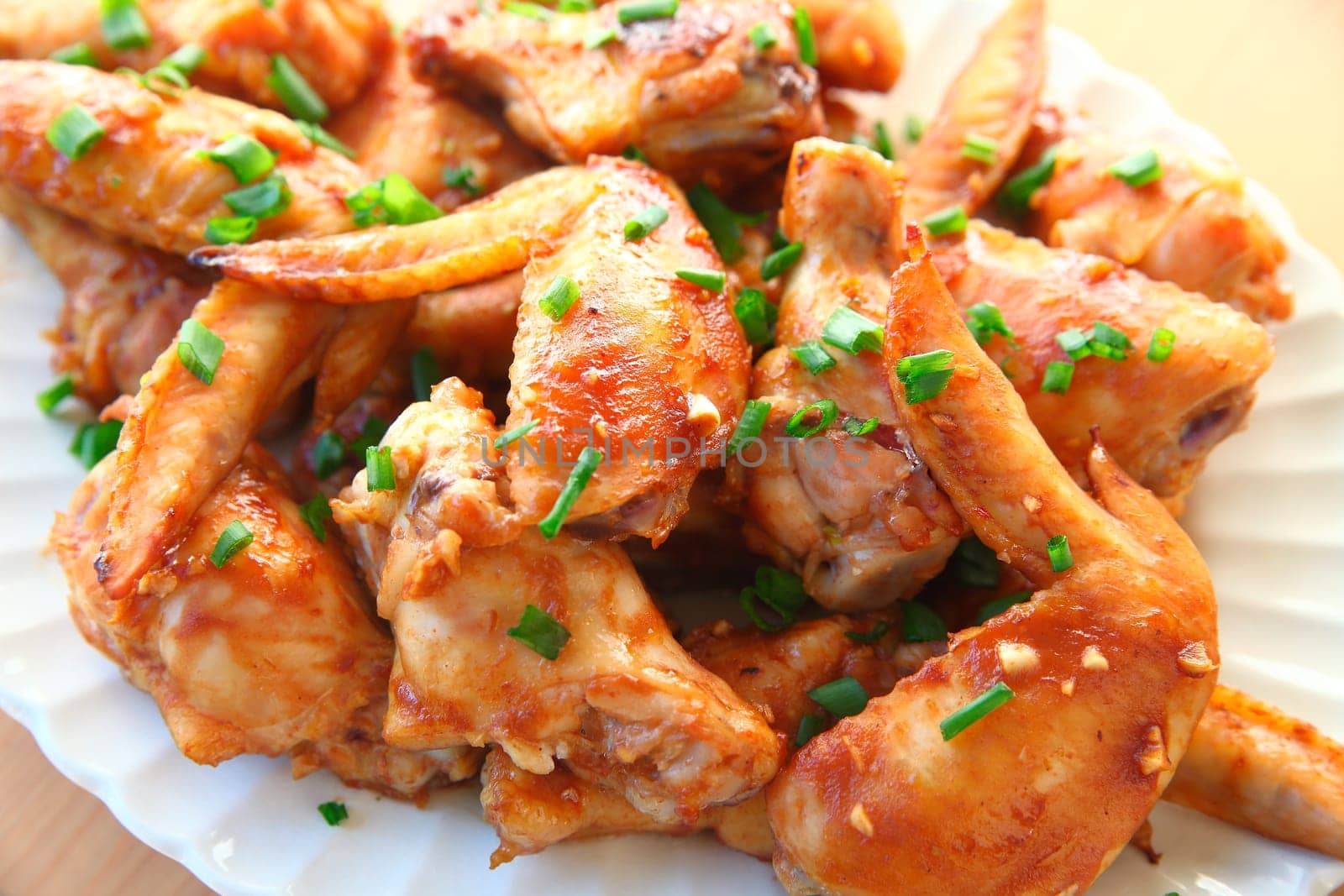 Closeup of chicken wings baked with a ketchup, soy and garlic based sauce
