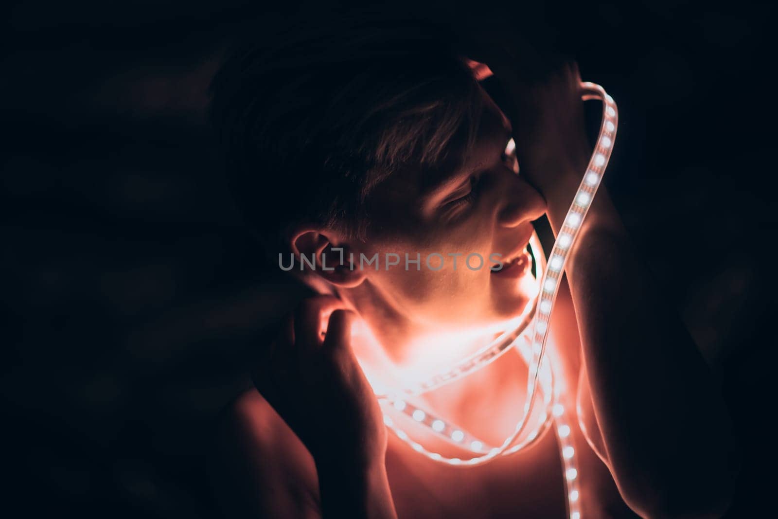 Portrait man Strip Light LED tape on dark color background.