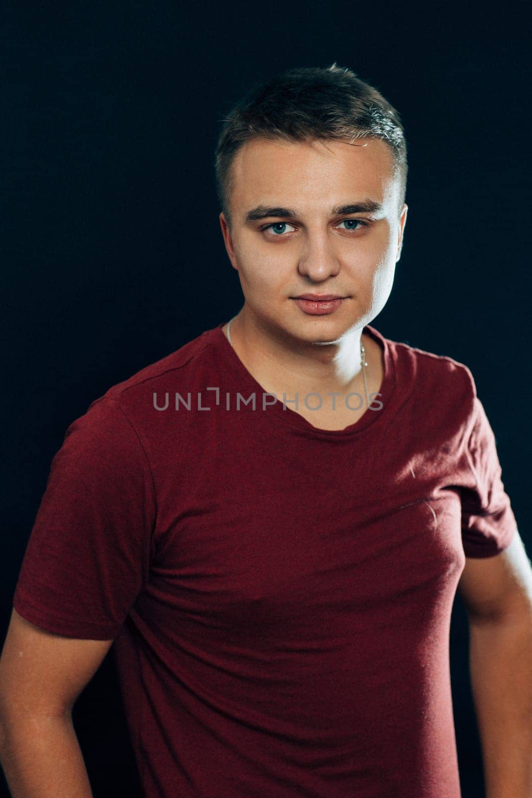 portrait of a young man on a dark background.