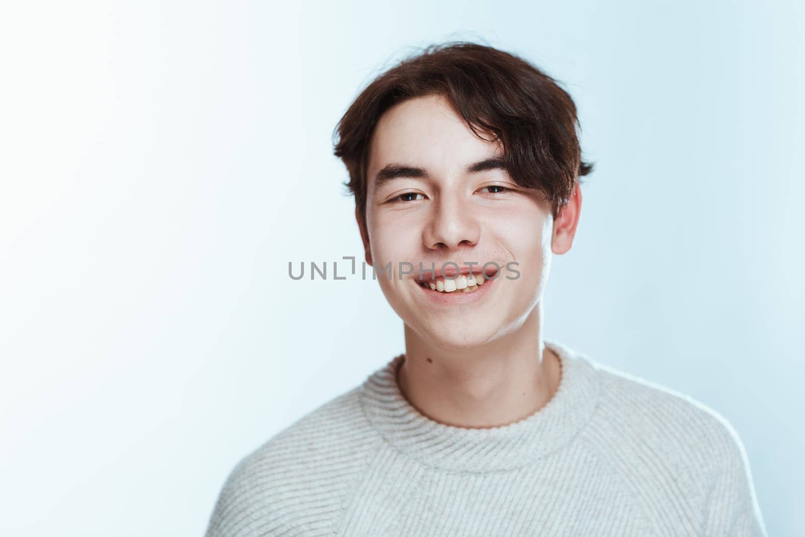 portrait of a teenager brunette guy in a studio.