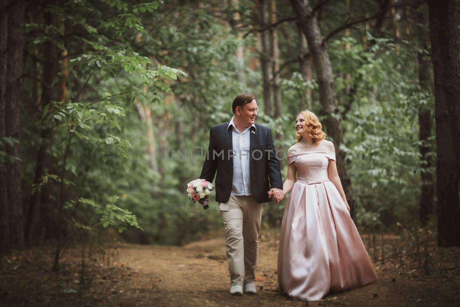 bride and groom kissing in the summer forest.