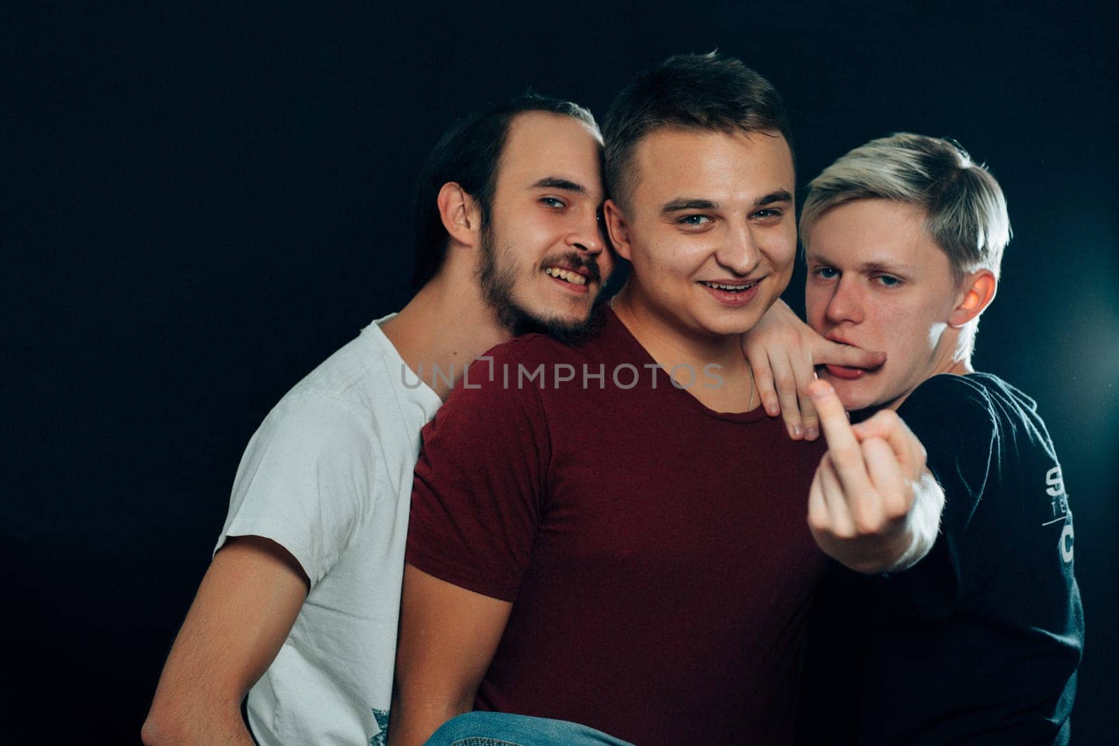 three guys are gay on dark background.
