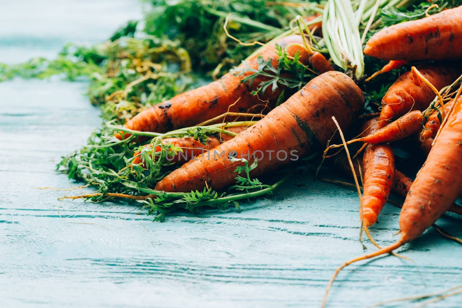 lot of carrots on a wooden background.