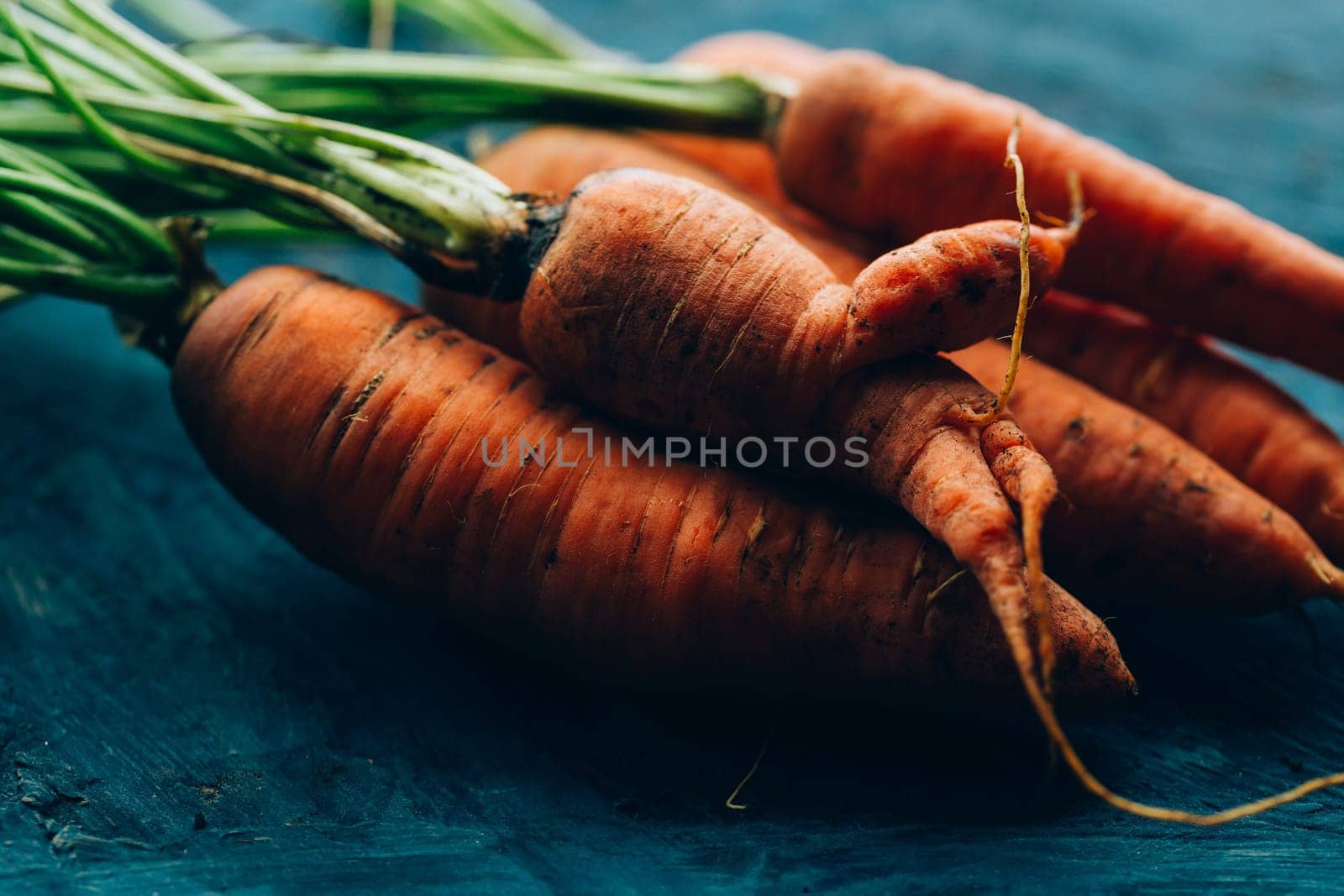 Fresh carrots on a blue wooden background.