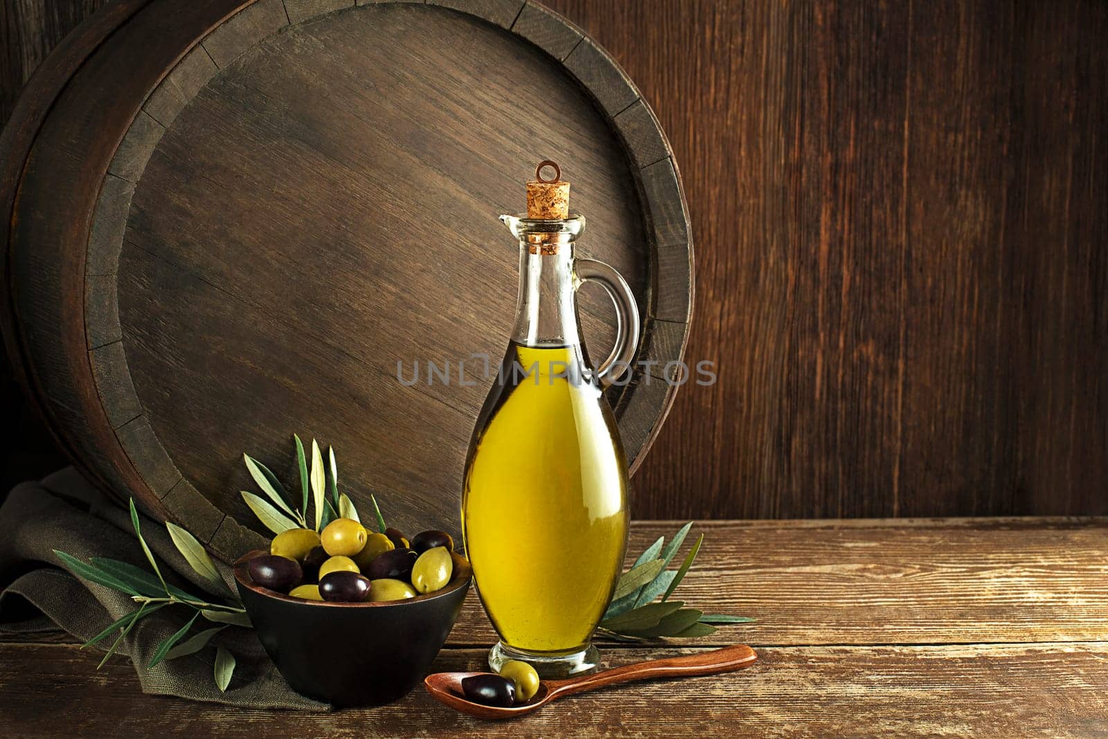 Bottle of Extra virgin healthy Olive oil with barrel background
