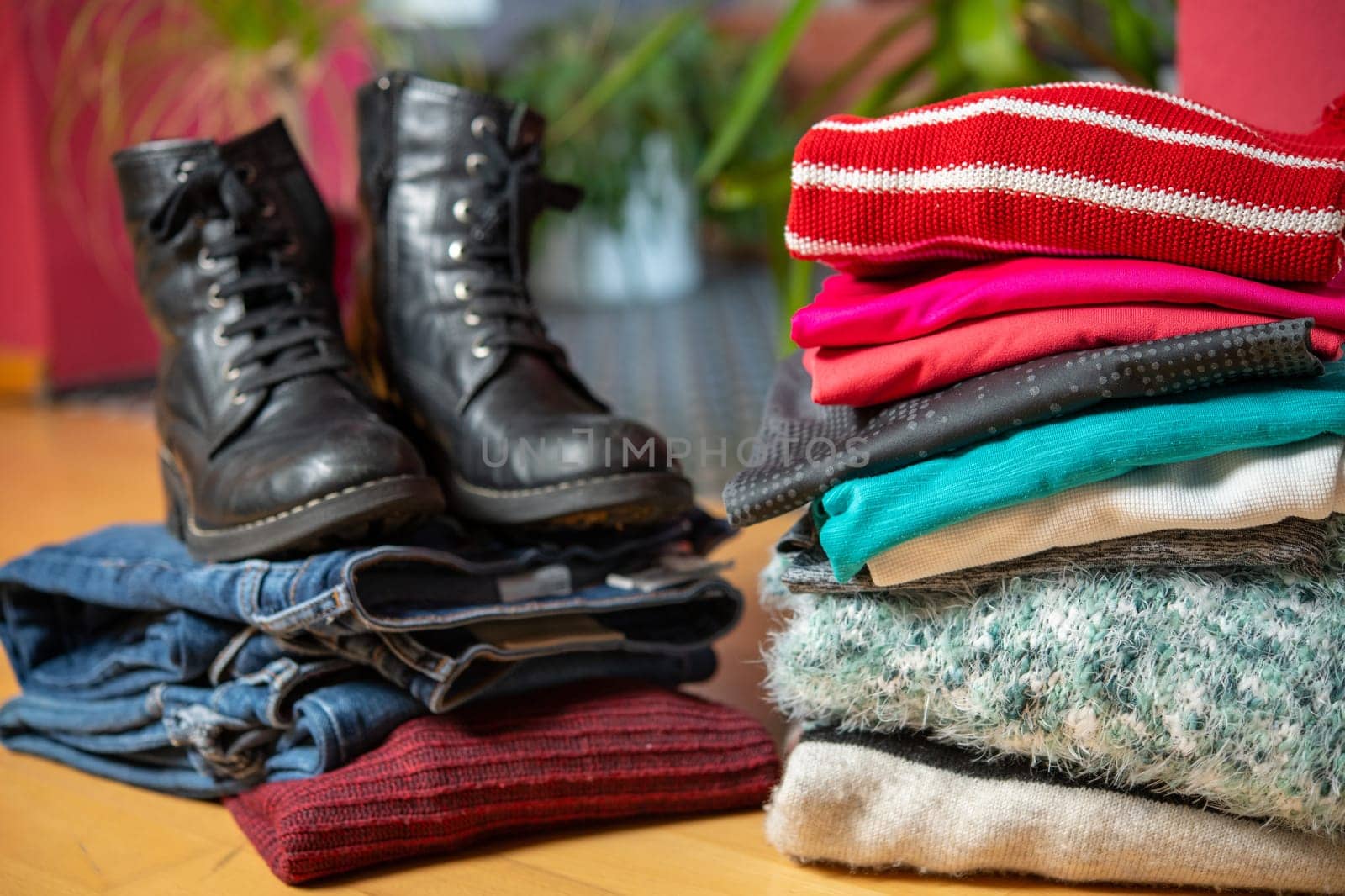 pile of second hand clothing and  shoes with computer on floor in living room