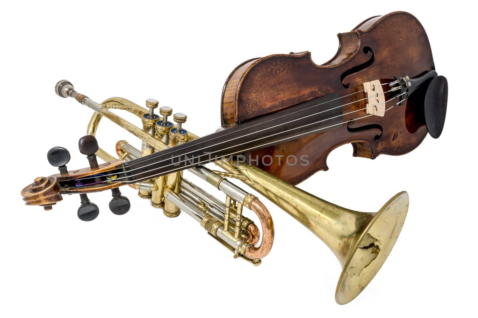 Old trumpet with scratches and dents and shiny violin isolated on white