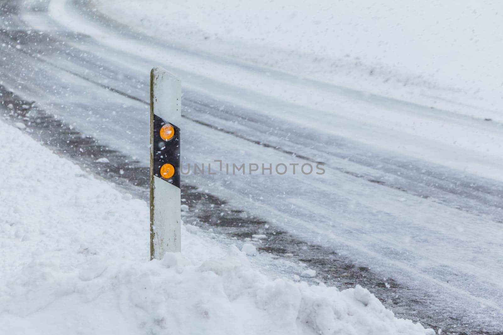 The street track is slick and frozen. High dangerous risk of an accident through the blizzard snowstorm and severe weather at christmas time season.