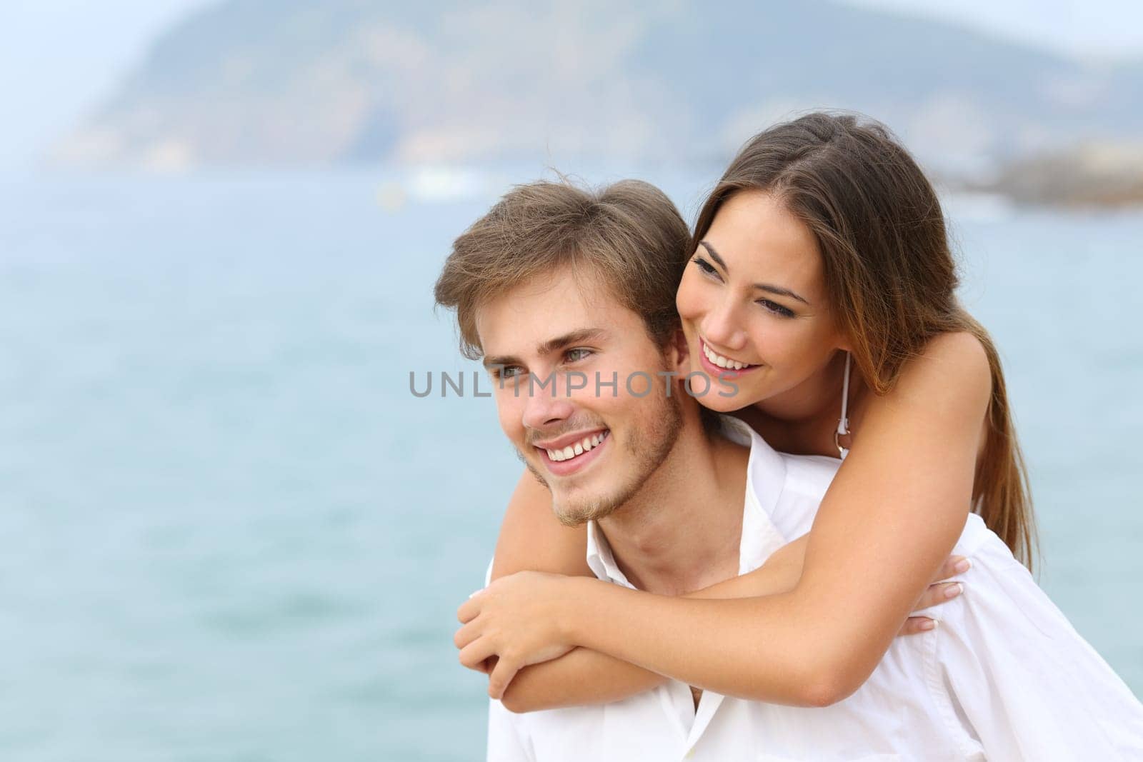 Happy couple joking on summer vacation on the beach