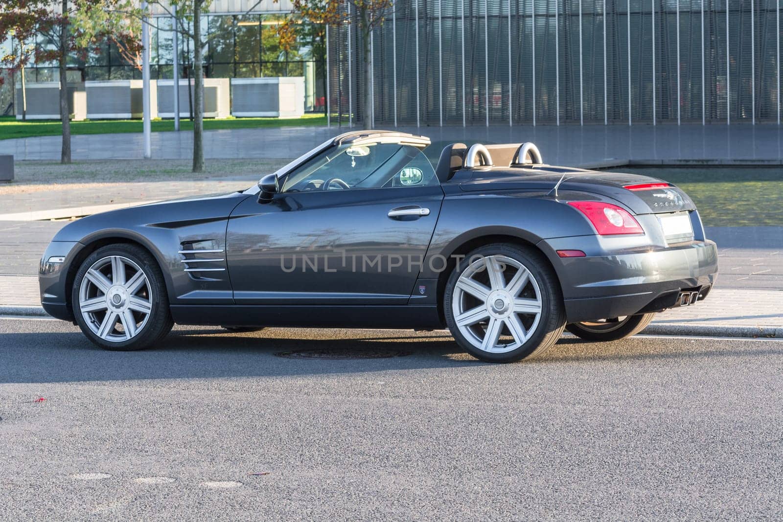 ESSEN, NRW, GERMANY - OCTOBER 11, 2015:.Chrysler Crossfire, side view of the new administrative building of ThyssenKrupp in Essen, Germany..