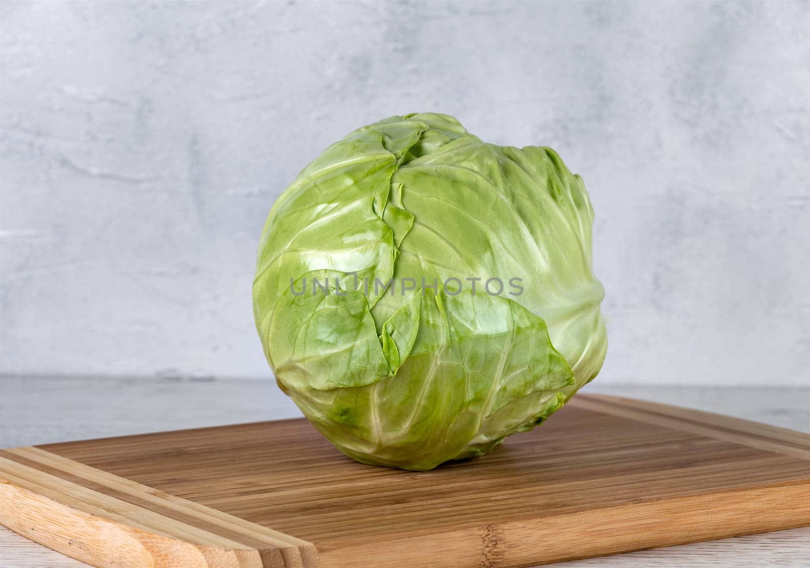Fresh green cabbage on a yellow cutting board