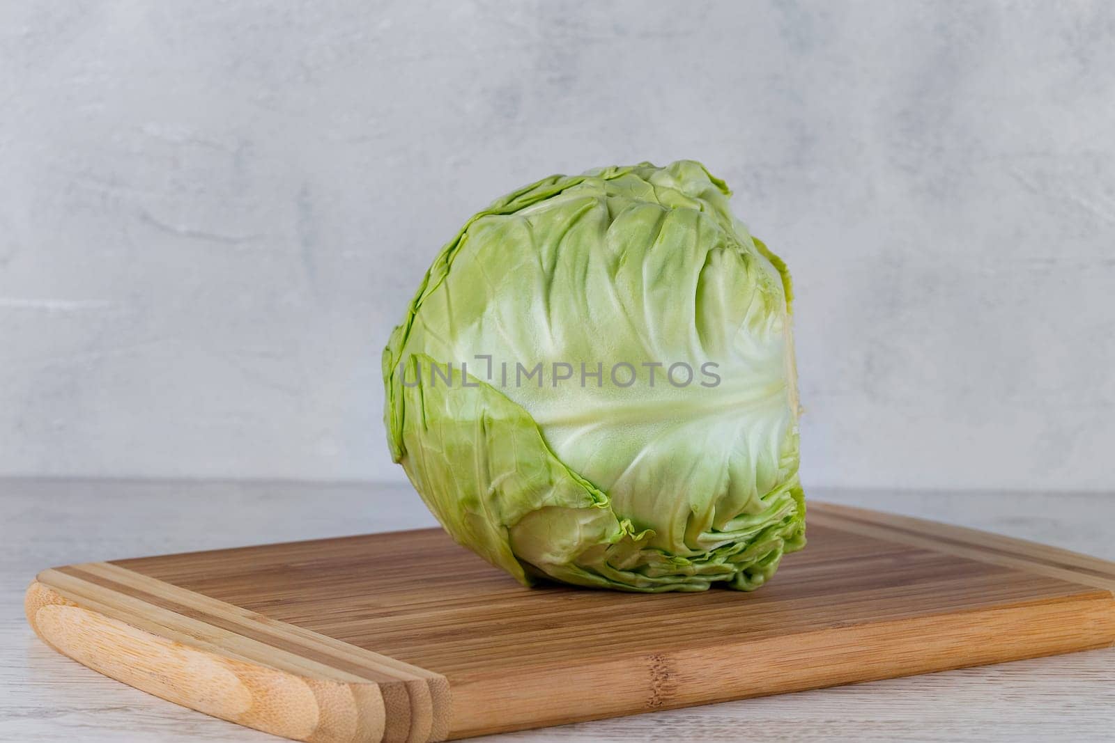 Fresh green cabbage on a yellow cutting board