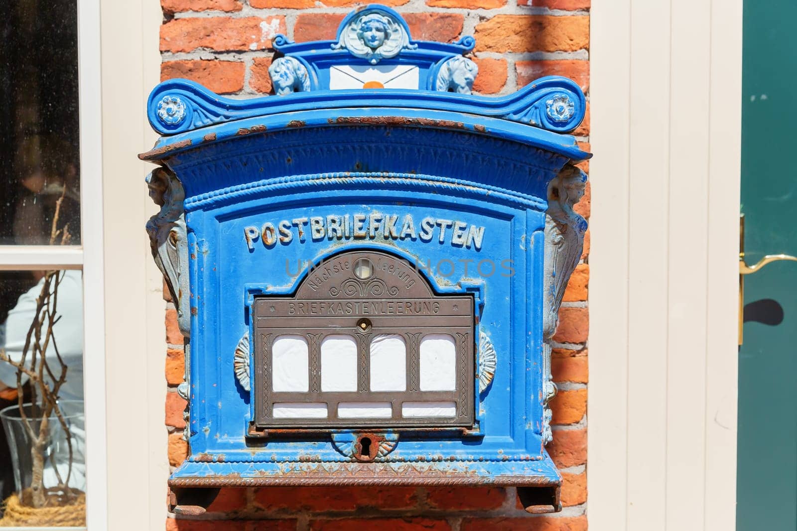 historical letter box at a house wall with the German writing of post letter box, next collection and letter box collection, seen in the old town of Leer, Ostfriesland, Germany