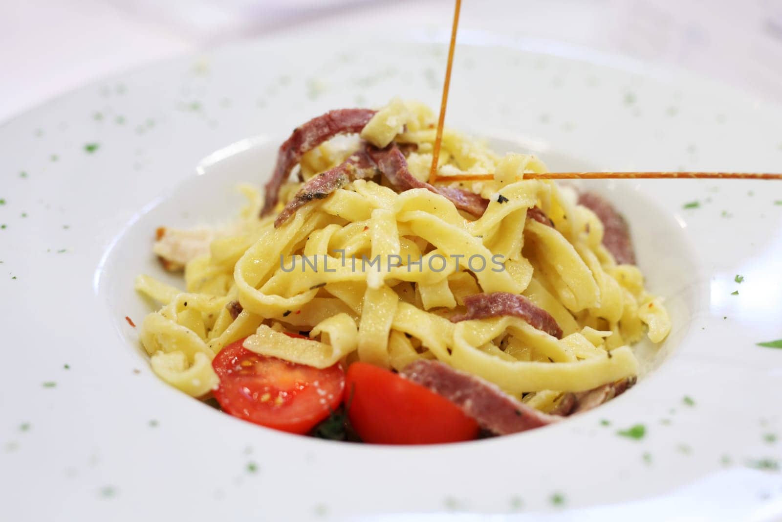 A plate of Fettucine with tomatoes and bacon