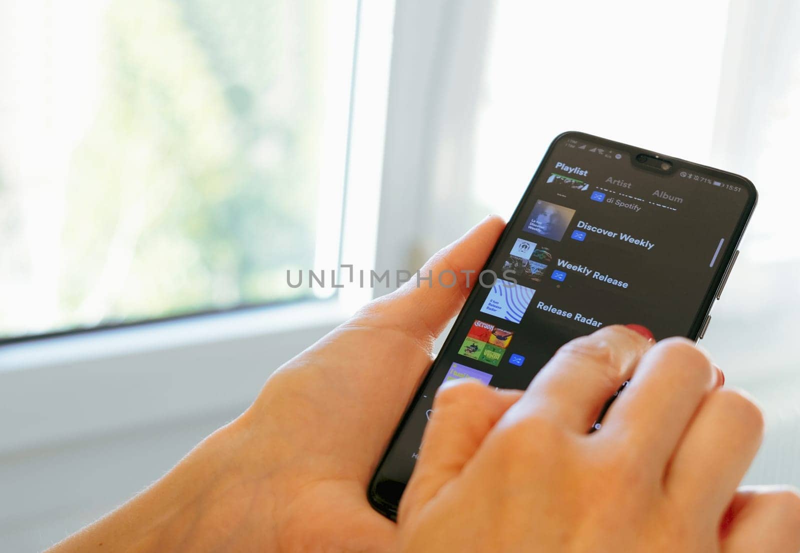 hand use Spotify app on smartphone scrolling down spotify playlists in Bologna, Italy, 08 March 2019