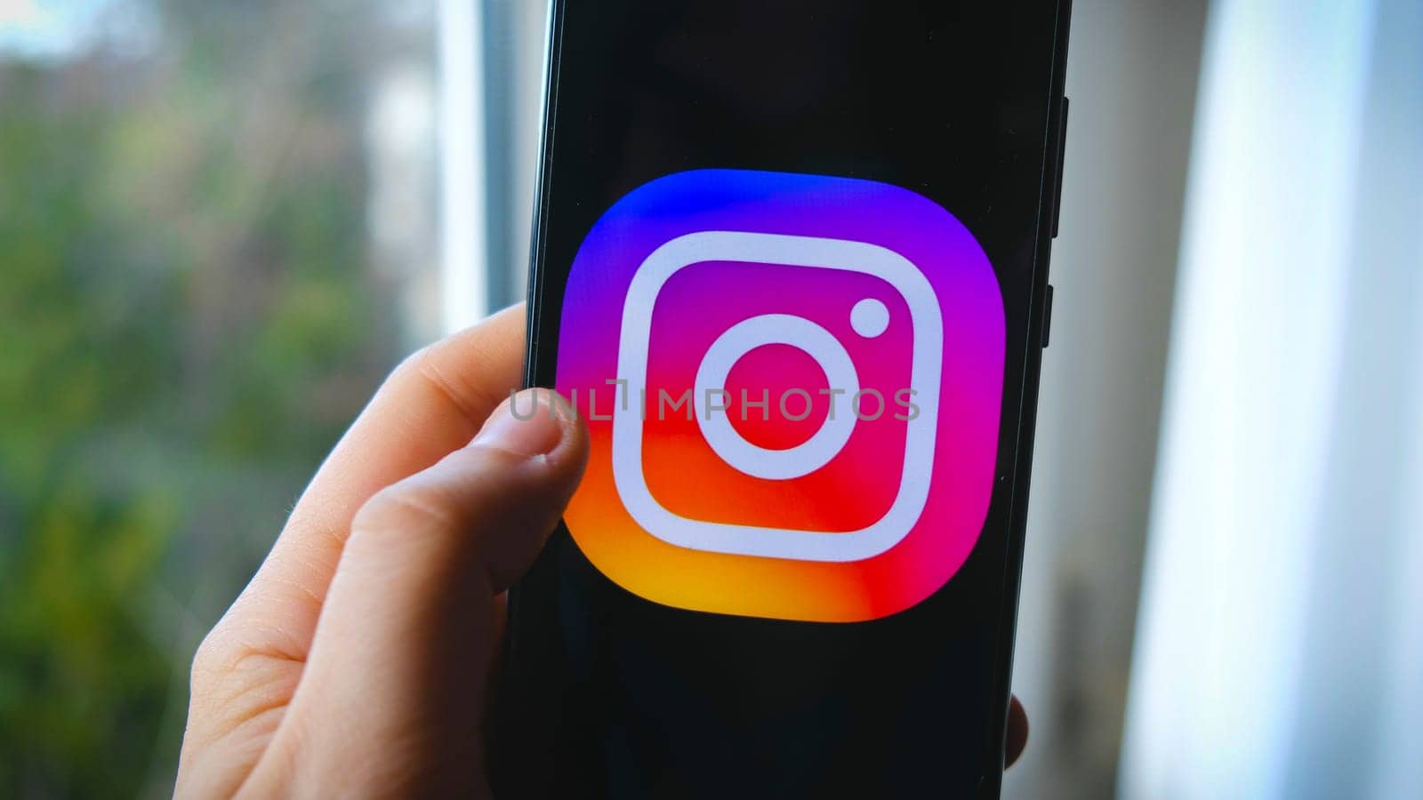 hand use Instagram app symbol on smartphone in Bologna, Italy, 08 March 2019