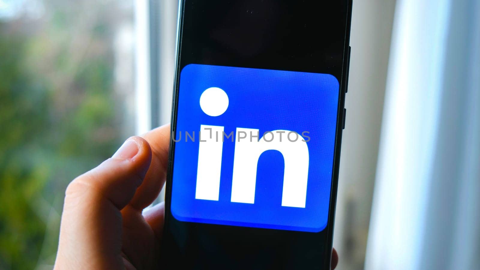 hand use Linkedin app symbol on smartphone in Bologna, Italy, 08 March 2019