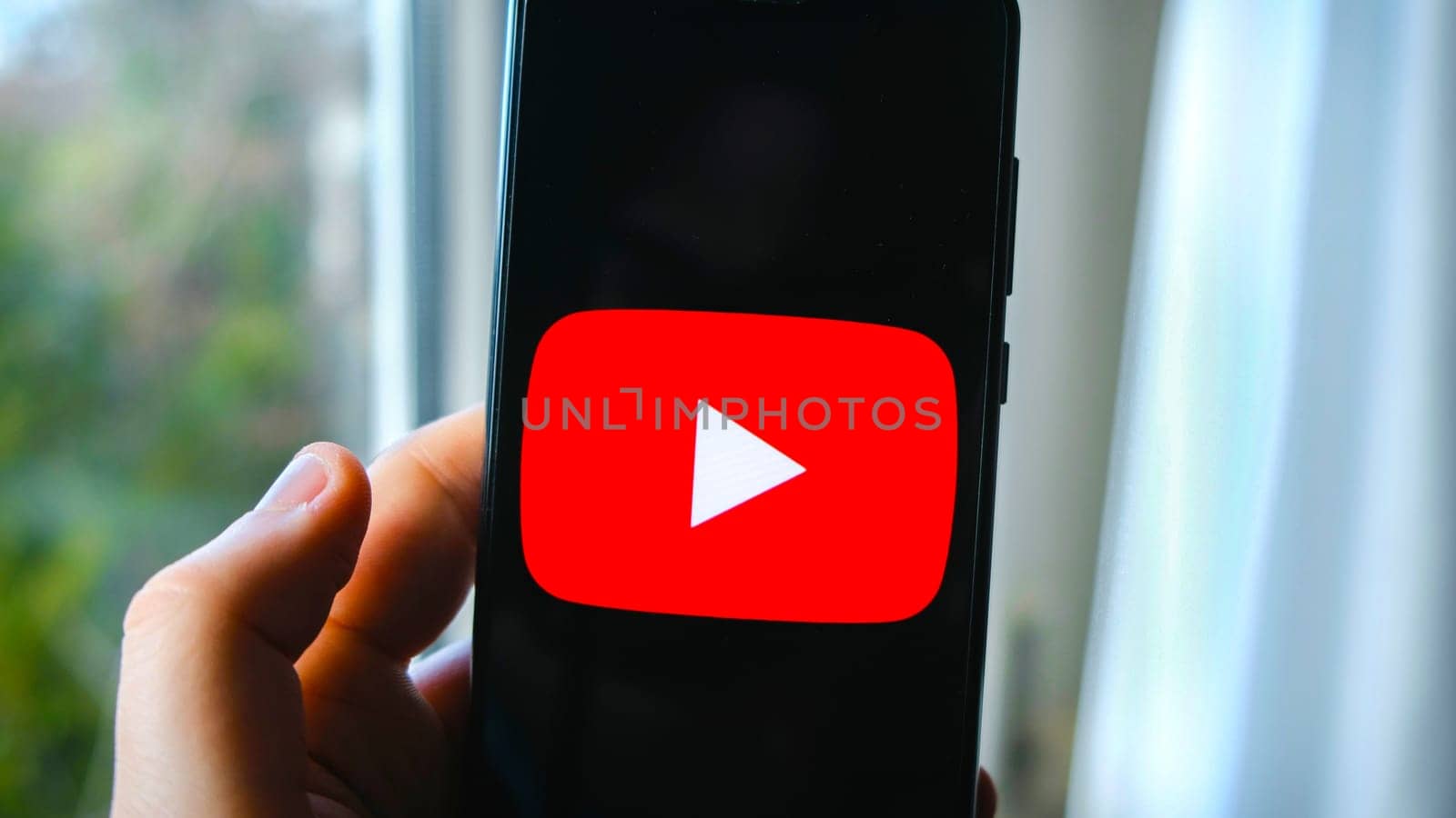 hand use YouTube app symbol on smartphone in Bologna, Italy, 08 March 2019