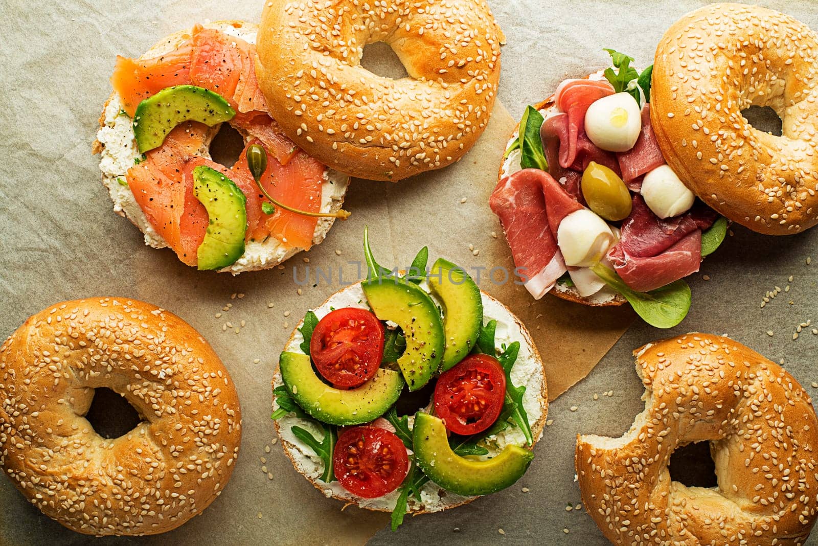 Bagel sandwich with avocado, salmon, prosciutto and mozzareela cheese. Healthy food.