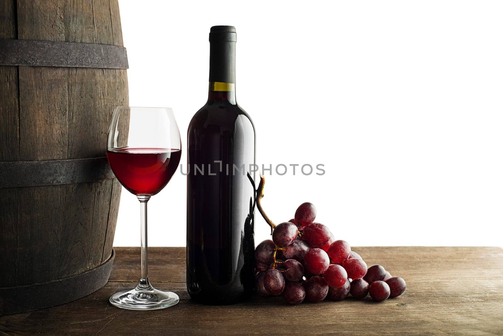 Glass and bottle of red wine on wooden background. Wine background on white