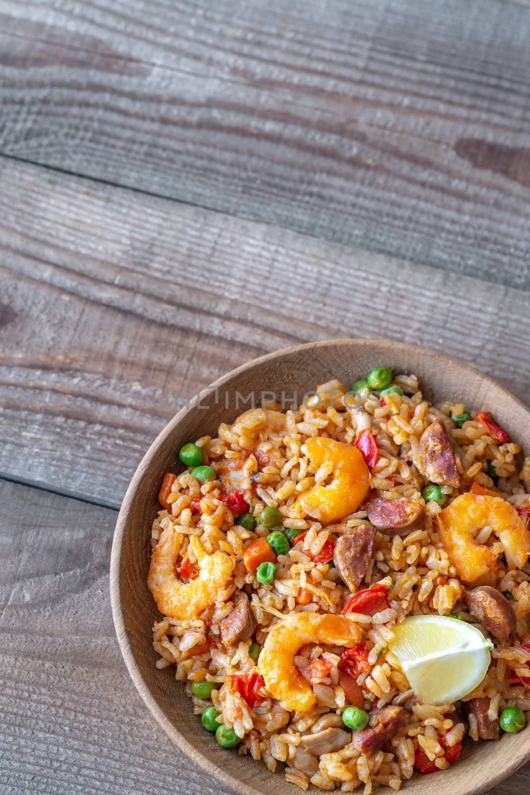 Bowl of chicken and chorizo paella with lemon wedge
