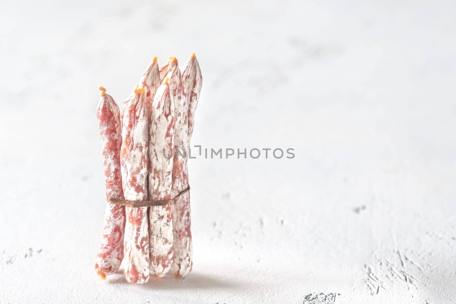 Snack fuet sausages on the wooden background