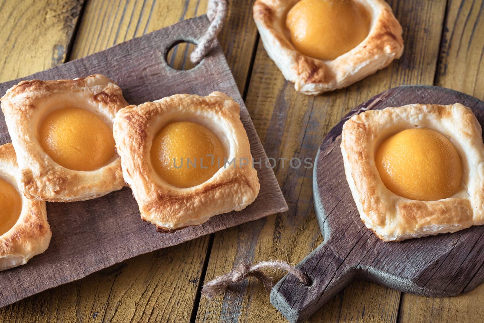 Puff pastry with canned peaches on the wooden table