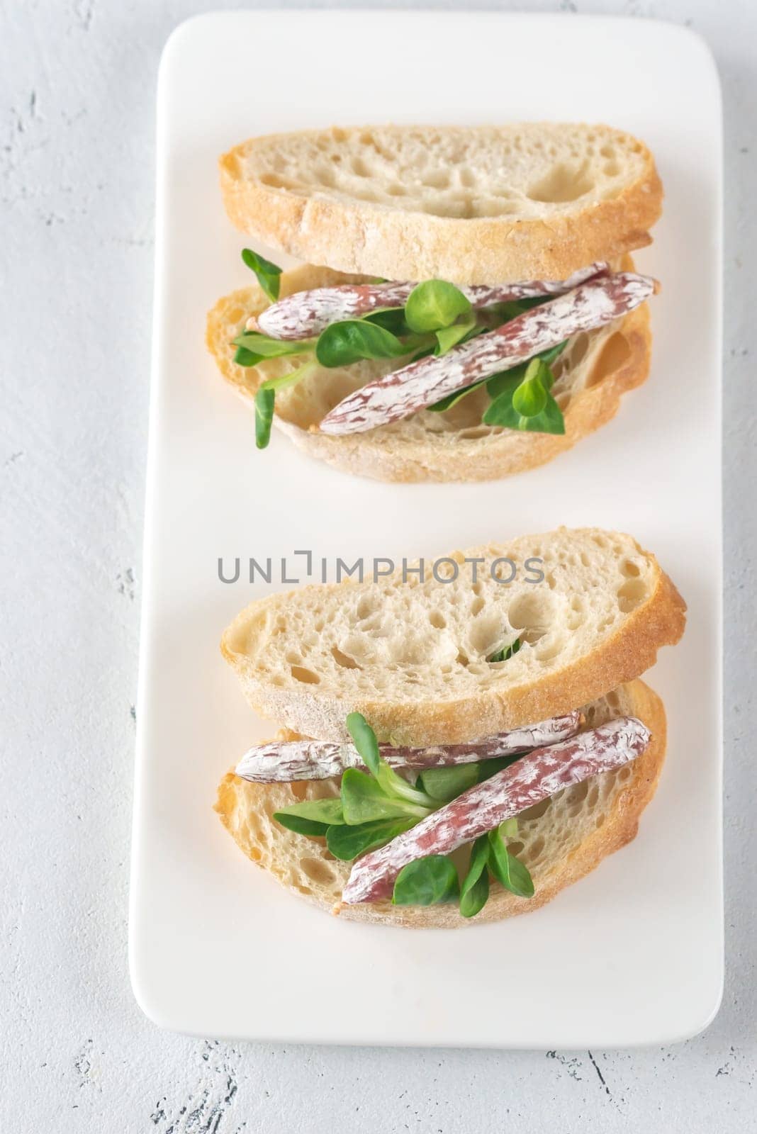 Sandwich with mini fuets and corn salad on the white background