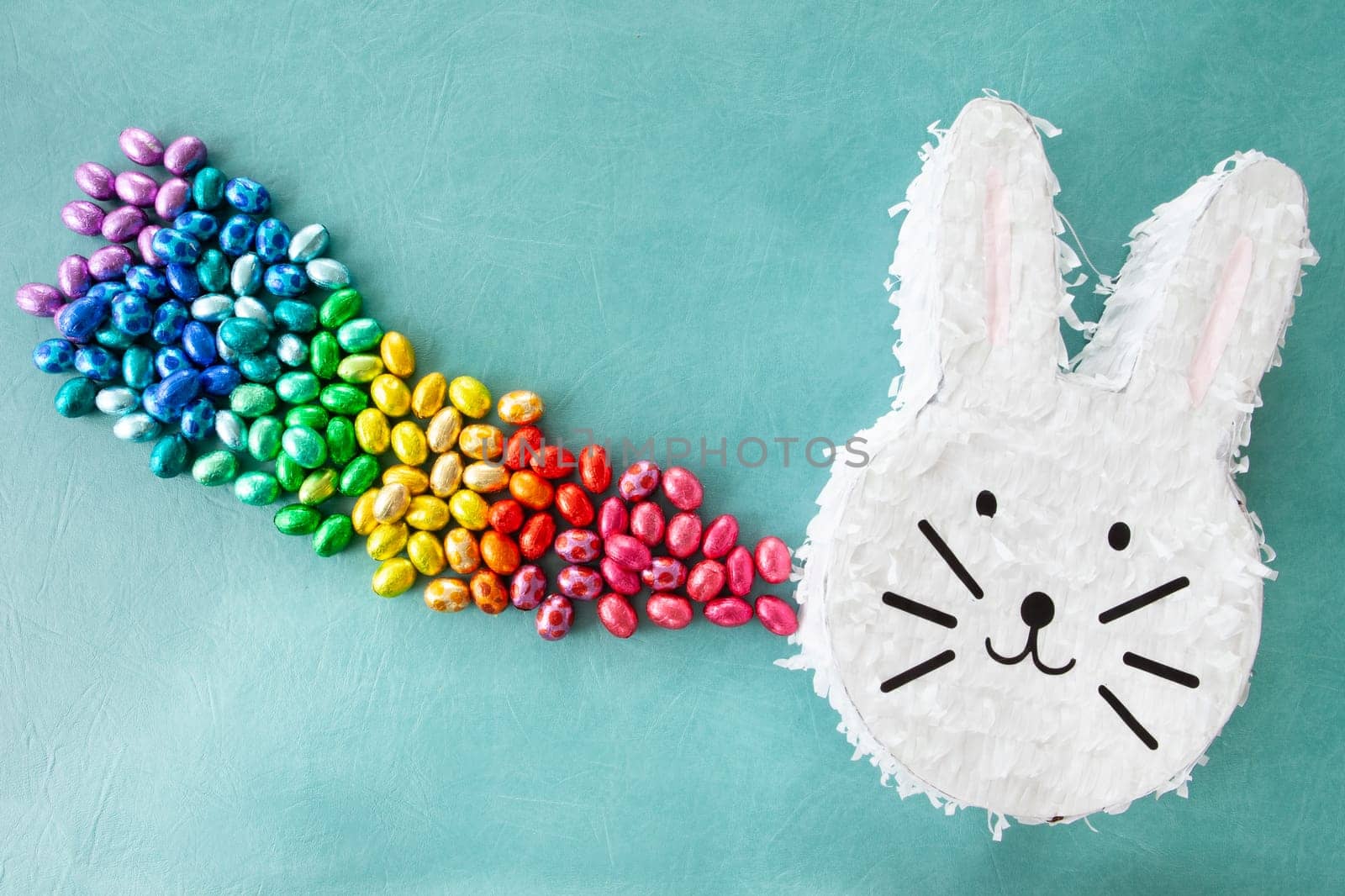 Cheerful Piñata with chocolate easter eggs in rainbow colors