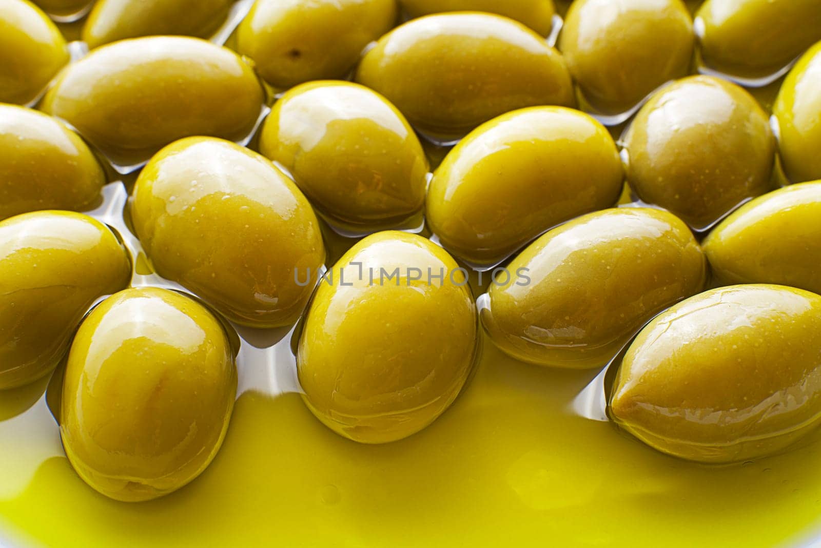 Extra virgin healthy Olive oil with fresh olives in plate close up