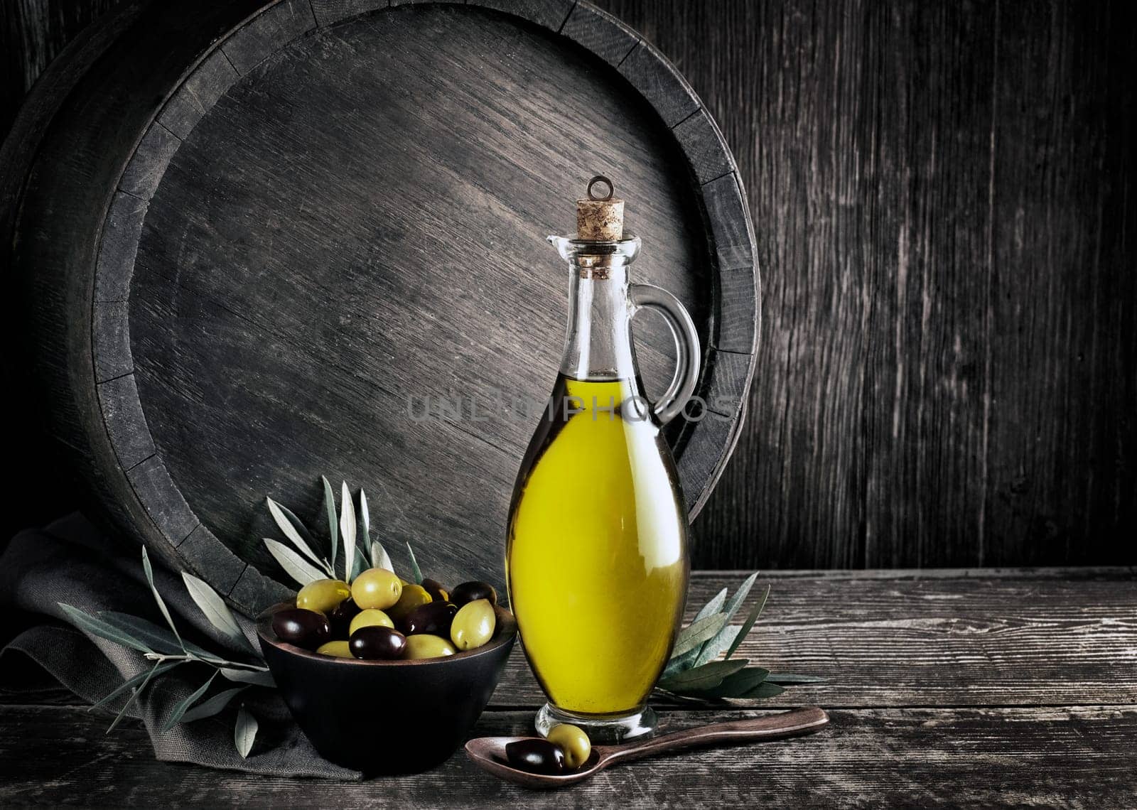 Bottle of Extra virgin healthy Olive oil with barrel background