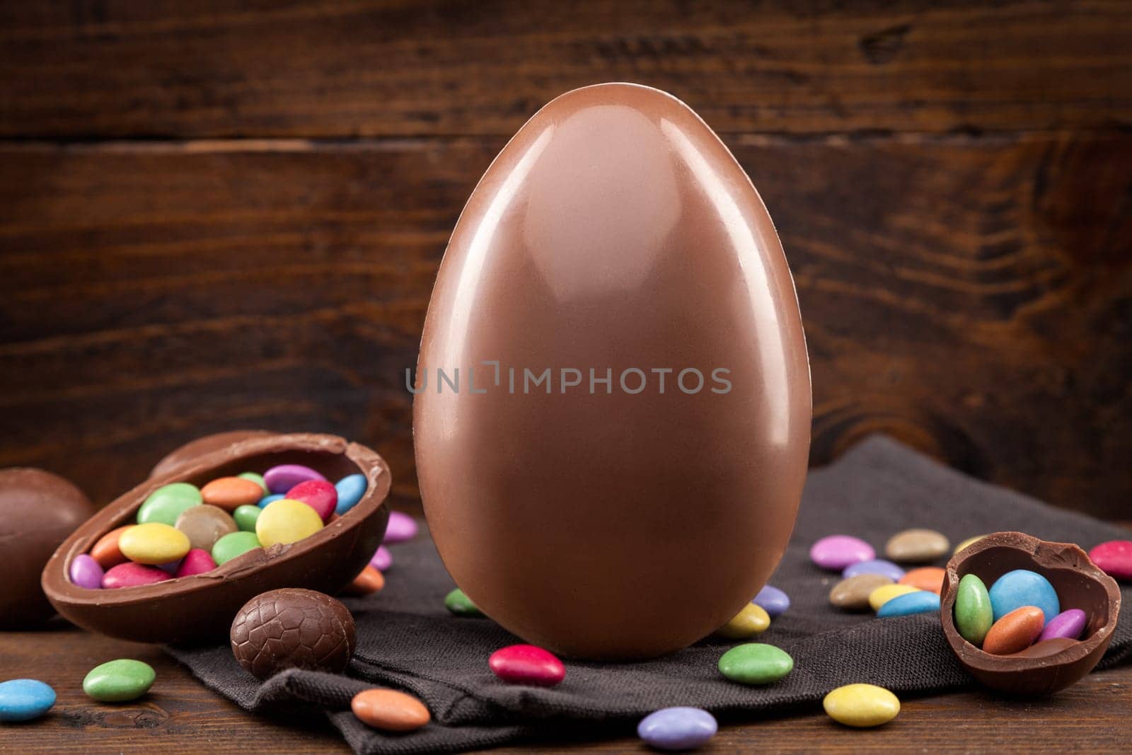 Delicious chocolate Easter holiday egg on rustic background