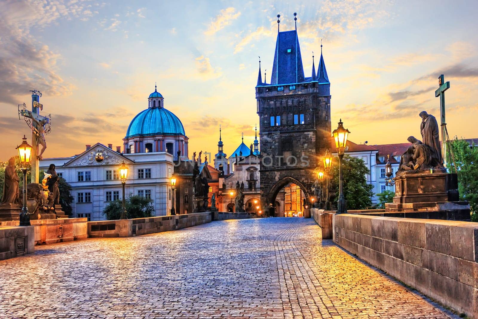 Charles Bridge and Old Town Bridge Tower in Prague at sunrise.