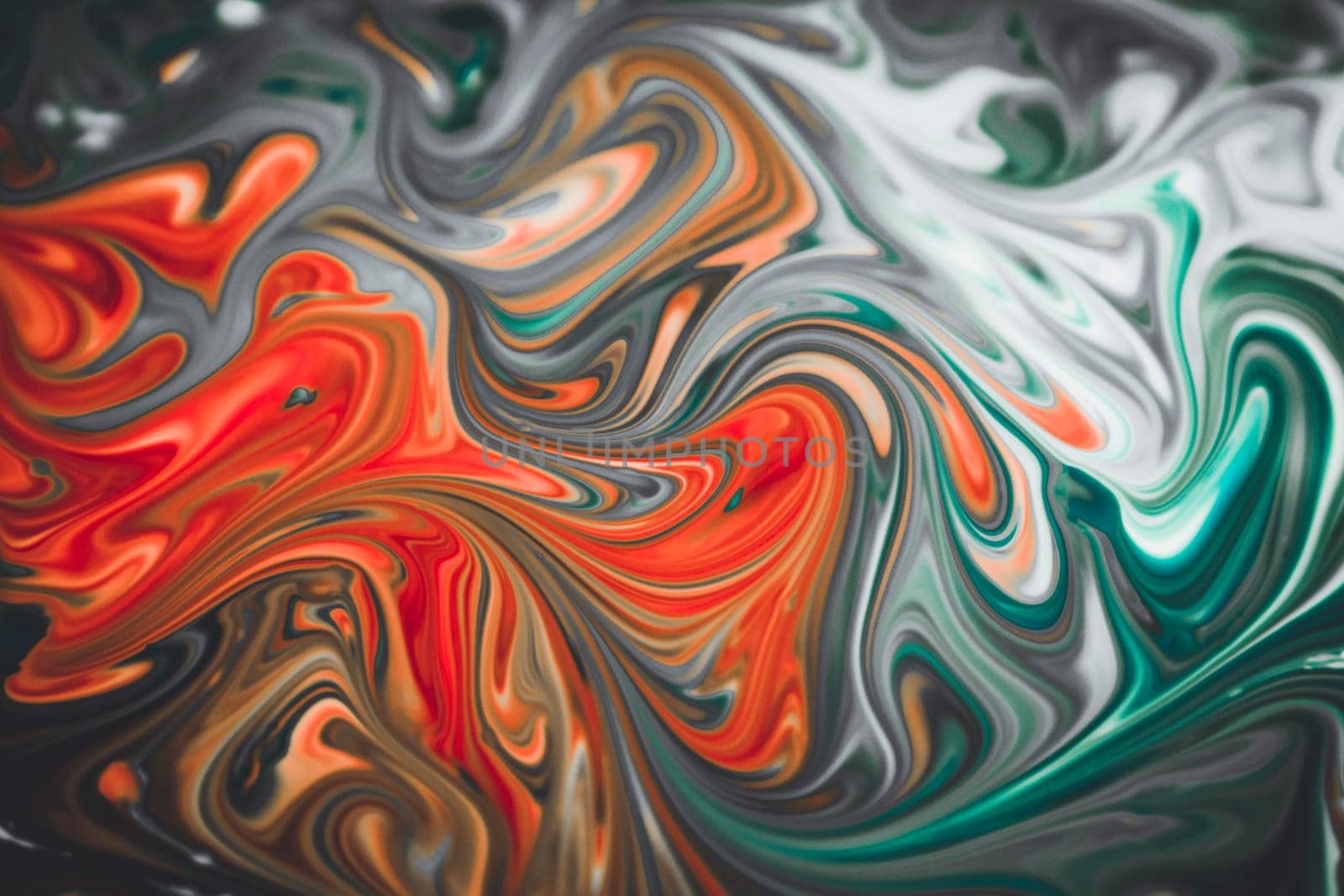 Colorful liquid paints mixed together creating modern abstract