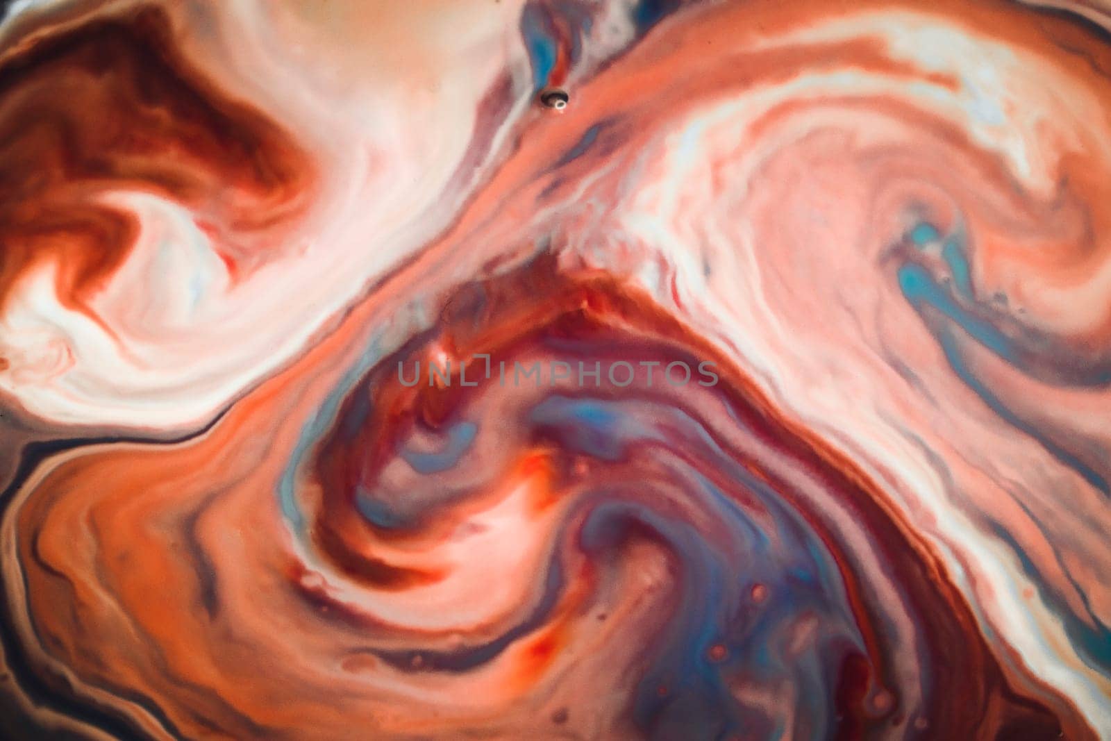 Colorful liquid paints mixed together creating modern abstract