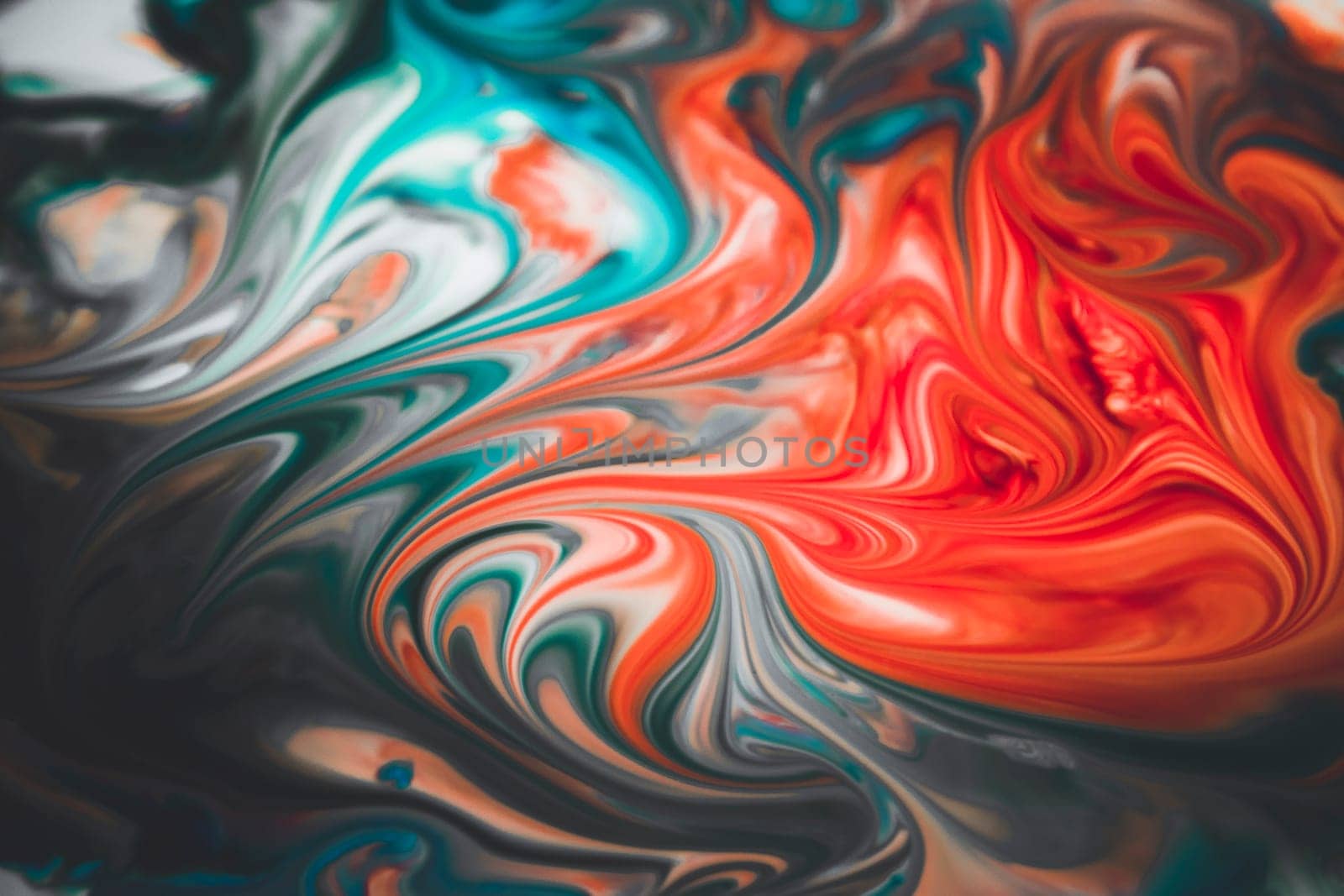Colorful liquid paints mixed together creating modern abstract
