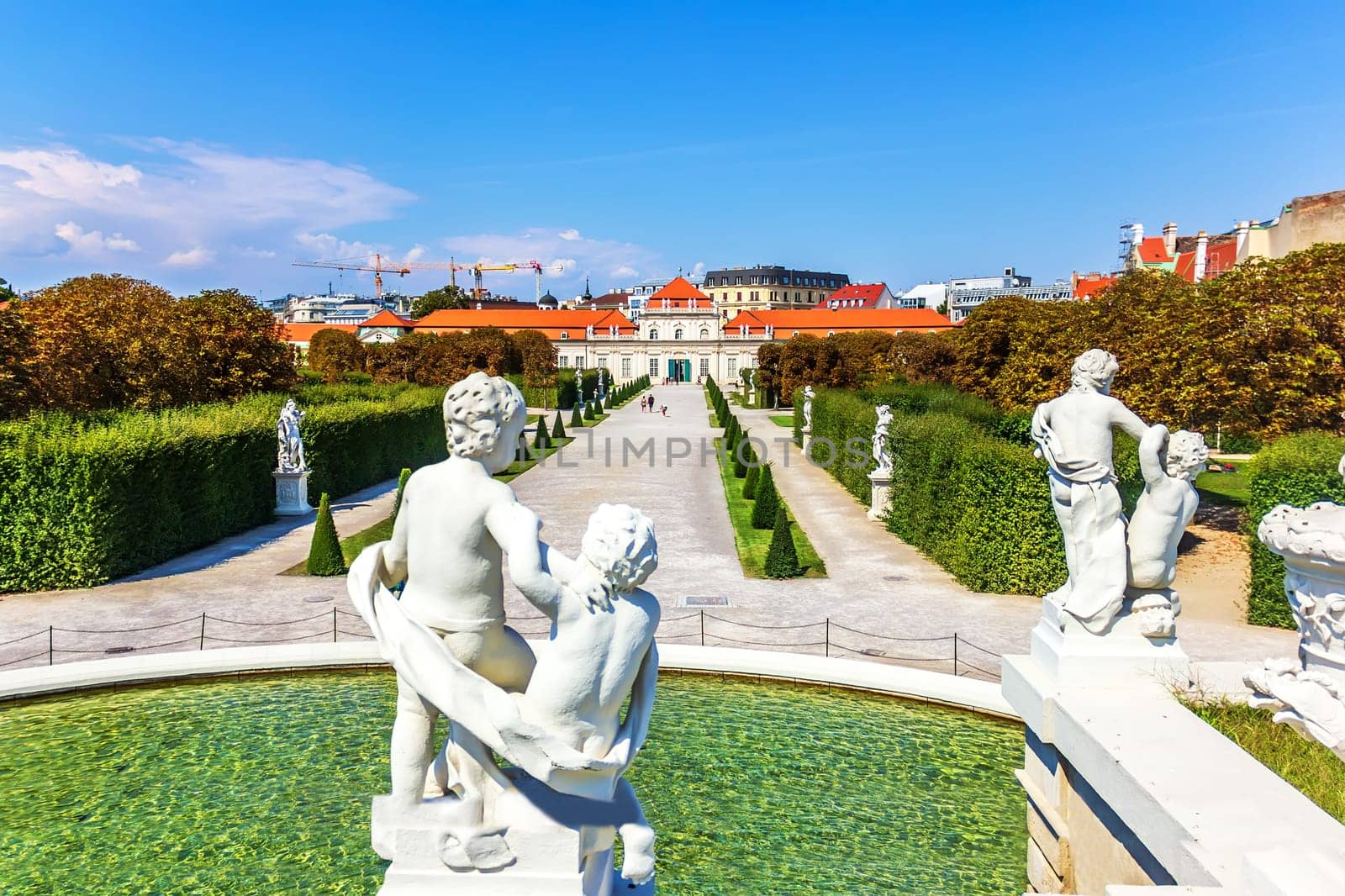 Statues on the fountain and view on Lower Belvedere Palace, Vienna.